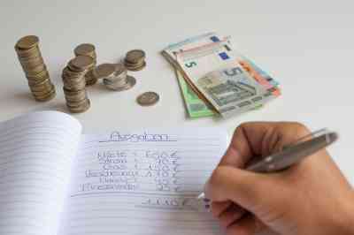 Person schreibt in Haushaltsbuch