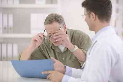 © mangostock - Fotolia.com Arzt zeigt Patient Akte