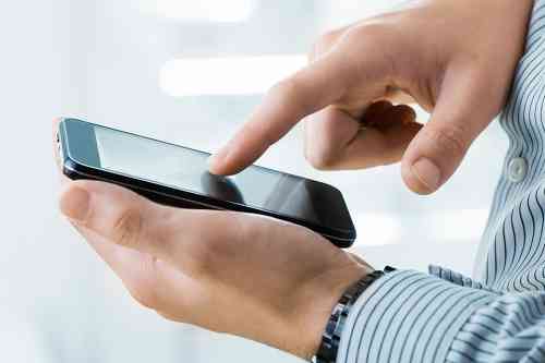 Person tippt auf Mobiltelefon